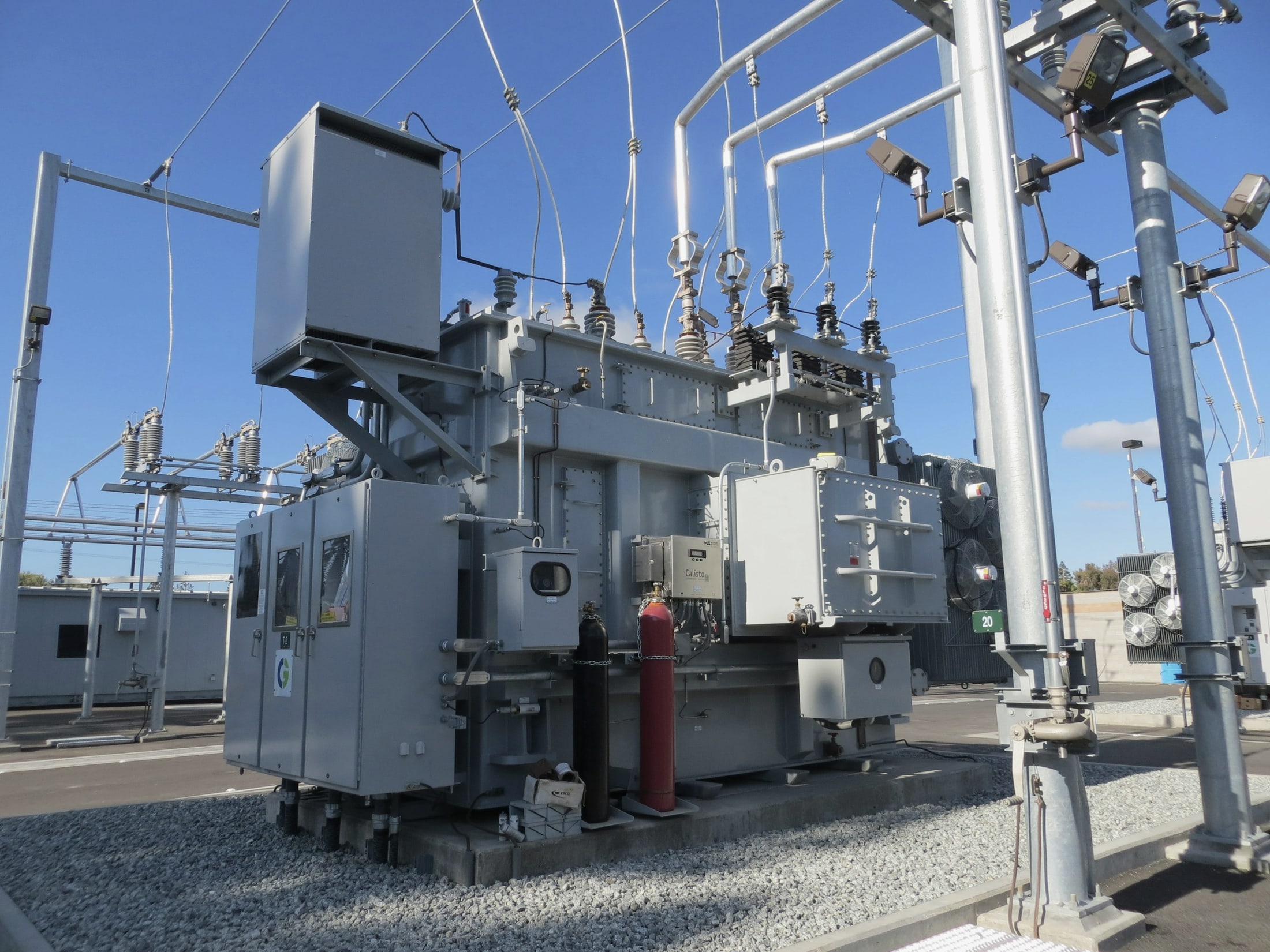 Electrical transformer and insulators at a power substation.